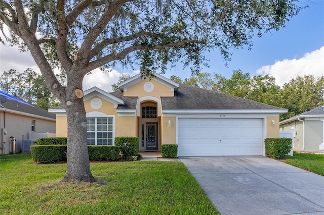 ranch-style home with a garage, a front lawn, and cooling unit