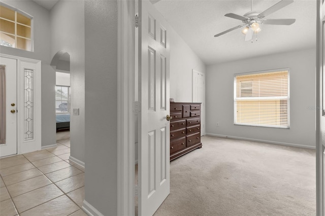 carpeted entryway featuring a textured ceiling and ceiling fan