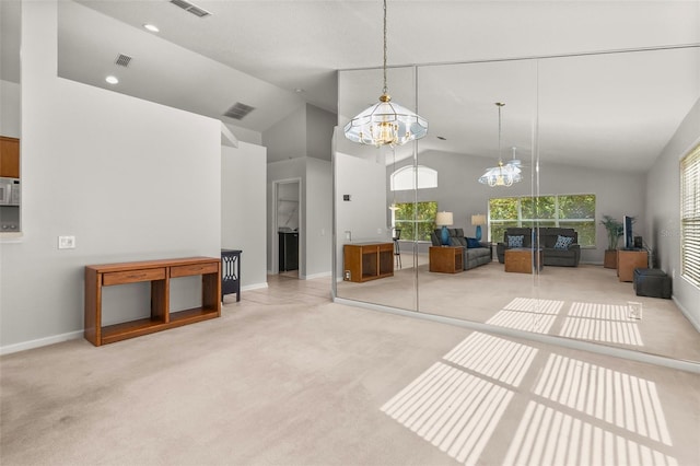 carpeted living room featuring high vaulted ceiling and an inviting chandelier