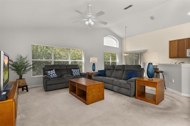 carpeted living room with high vaulted ceiling and ceiling fan