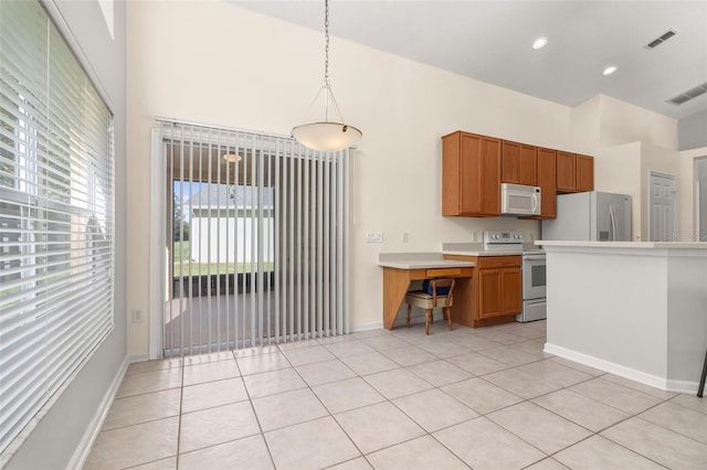 kitchen featuring light tile patterned floors, hanging light fixtures, and white appliances