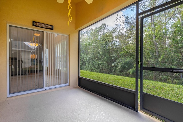 unfurnished sunroom with ceiling fan