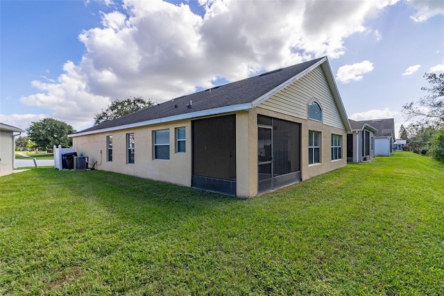 view of side of property with a sunroom, a yard, and central AC unit