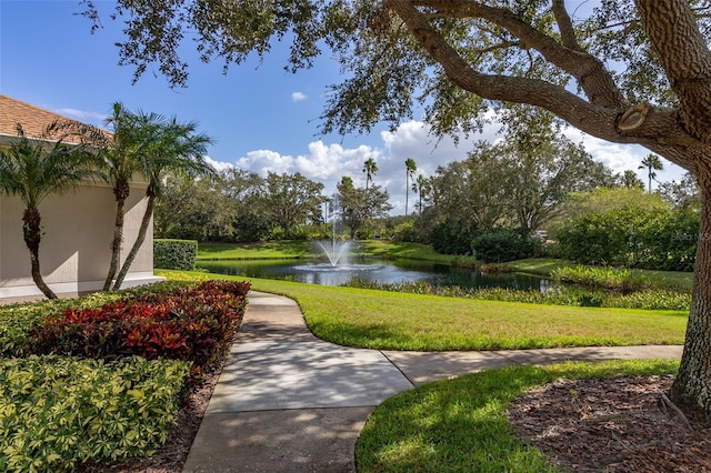 surrounding community featuring a water view and a yard