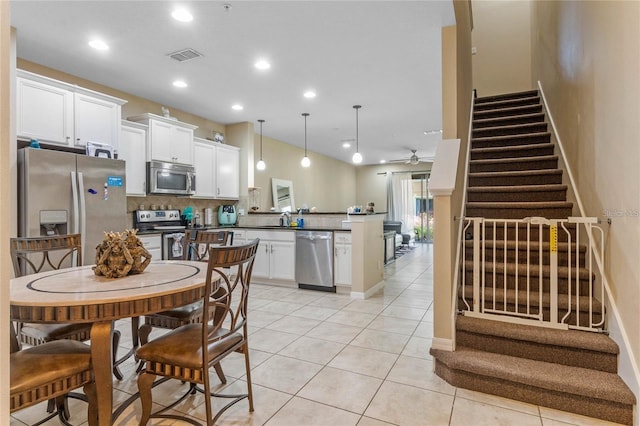 tiled dining space featuring ceiling fan and sink