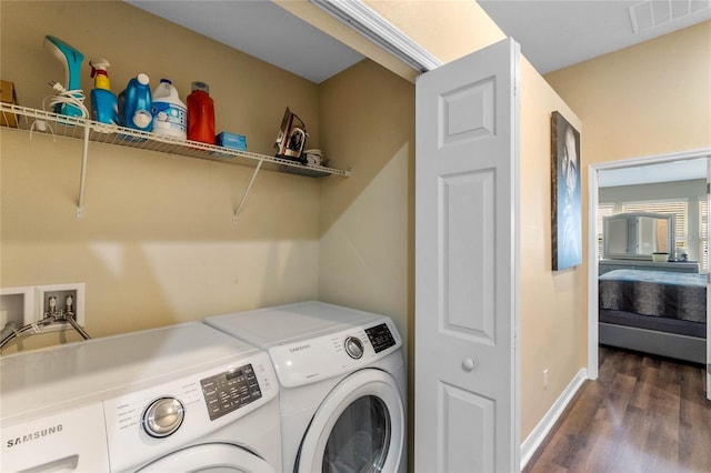 laundry room with washer and dryer and dark hardwood / wood-style flooring