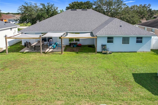 rear view of house with a lawn and a patio