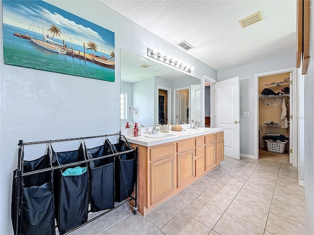 bathroom featuring tile patterned flooring, vanity, and a textured ceiling