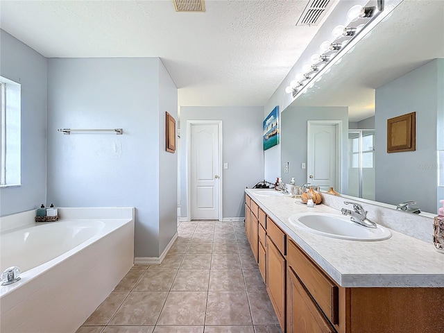 bathroom with vanity, a textured ceiling, tile patterned floors, and plus walk in shower