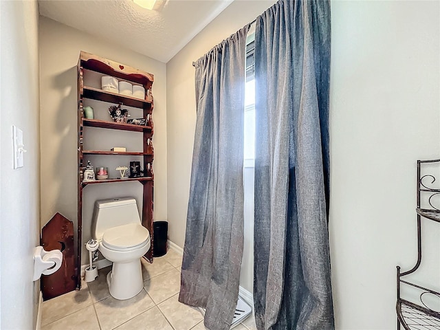 bathroom with tile patterned floors, toilet, and a textured ceiling