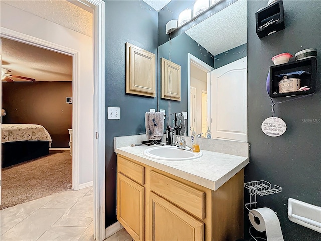 bathroom featuring tile patterned floors, vanity, ceiling fan, and a textured ceiling