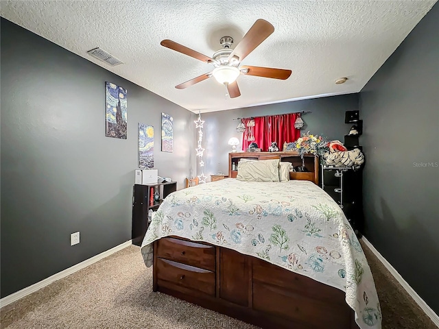 carpeted bedroom featuring ceiling fan and a textured ceiling