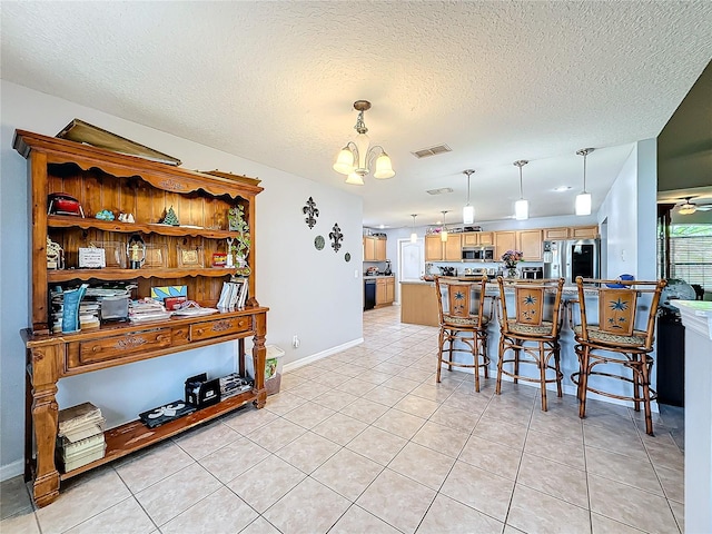 tiled dining room featuring ceiling fan with notable chandelier and a textured ceiling