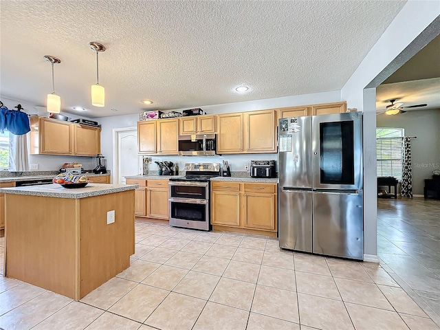 kitchen with a center island, ceiling fan, light tile patterned floors, decorative light fixtures, and stainless steel appliances