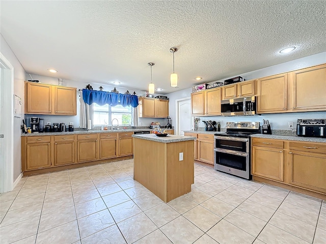 kitchen with sink, light tile patterned floors, appliances with stainless steel finishes, decorative light fixtures, and a kitchen island