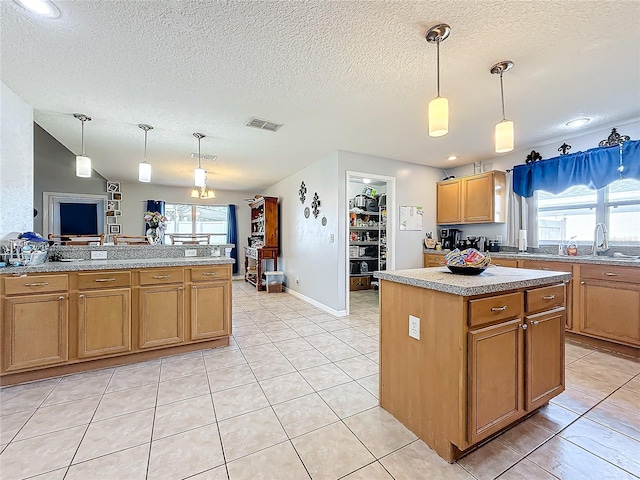 kitchen with a wealth of natural light, a center island, and pendant lighting