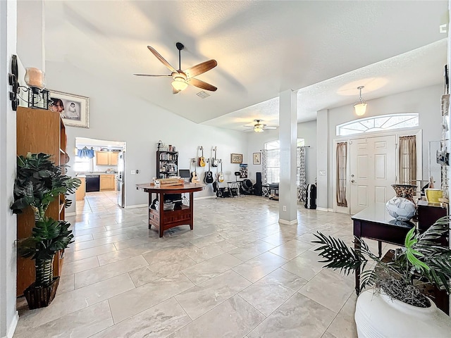 interior space with ceiling fan, lofted ceiling, and a textured ceiling