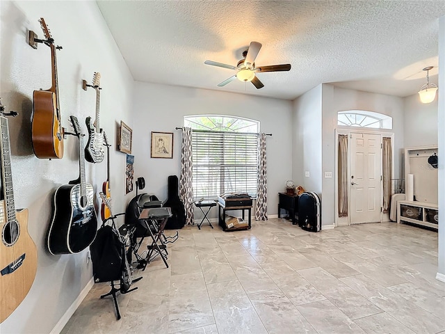 interior space featuring ceiling fan and a textured ceiling