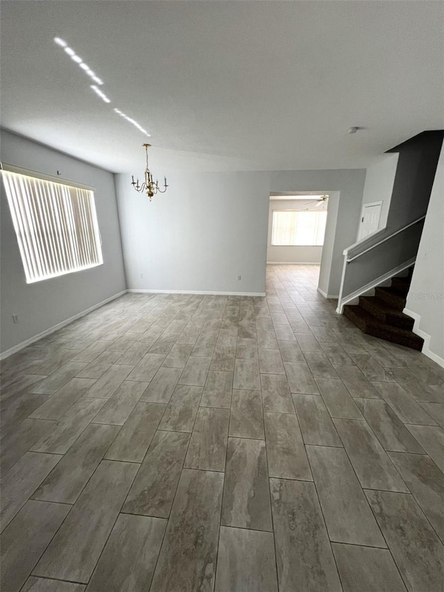 unfurnished room featuring a chandelier and hardwood / wood-style flooring