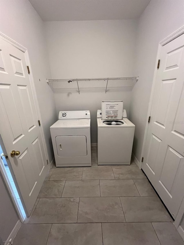 laundry area featuring light tile patterned floors and washing machine and dryer