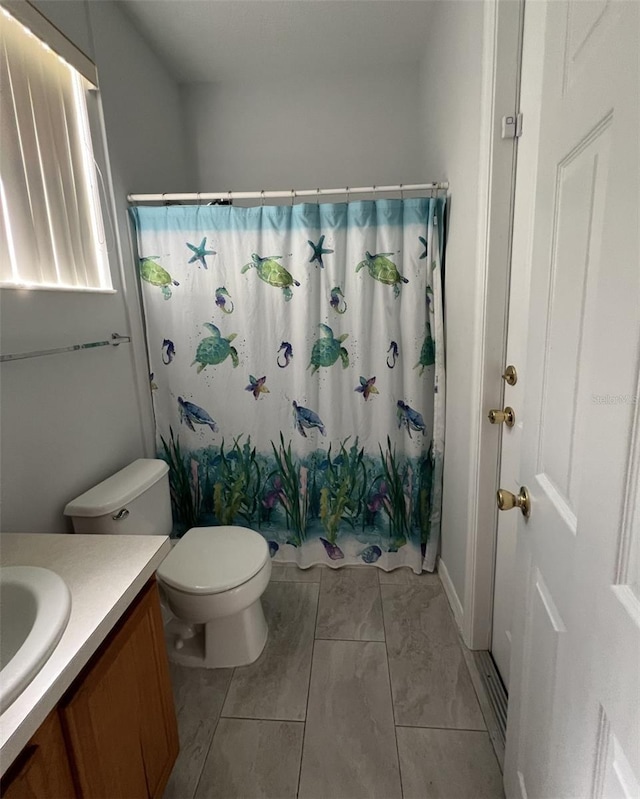 bathroom with toilet, vanity, and a shower with shower curtain