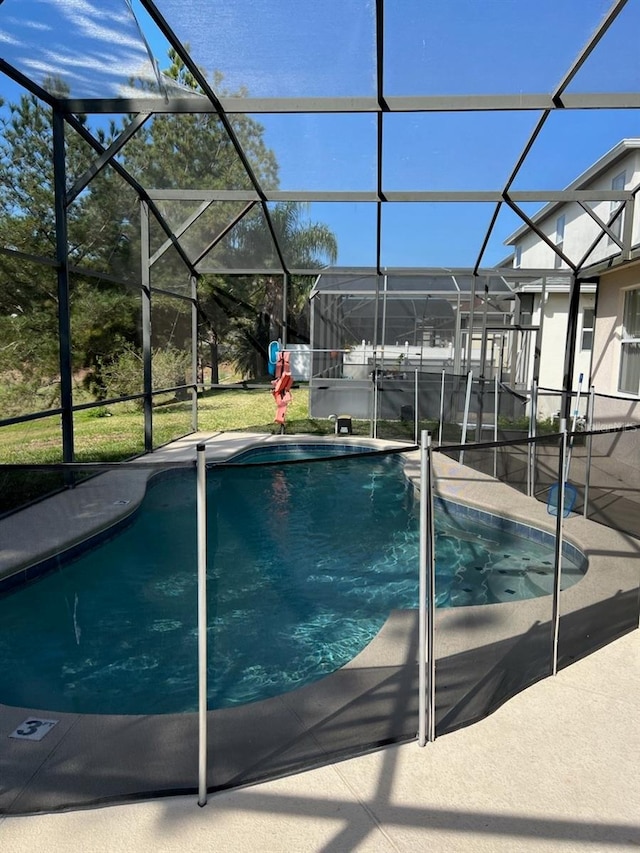 view of swimming pool with glass enclosure and a patio area