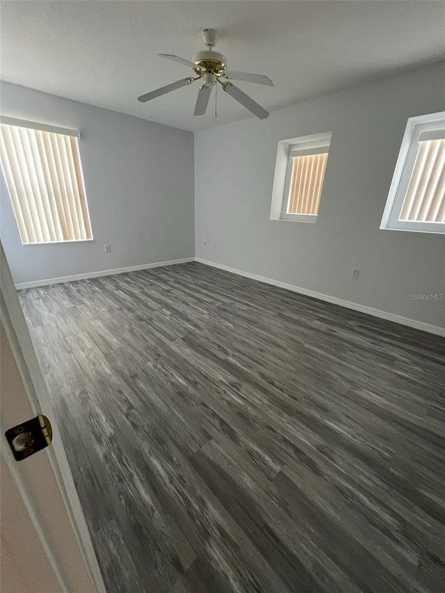 empty room featuring dark hardwood / wood-style floors, ceiling fan, and a healthy amount of sunlight