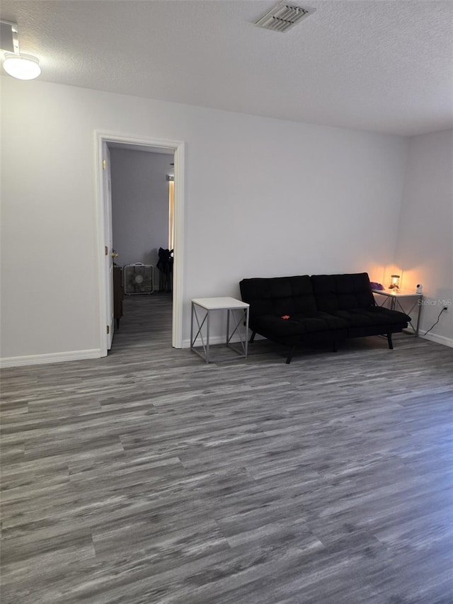 living room featuring dark wood-type flooring and a textured ceiling