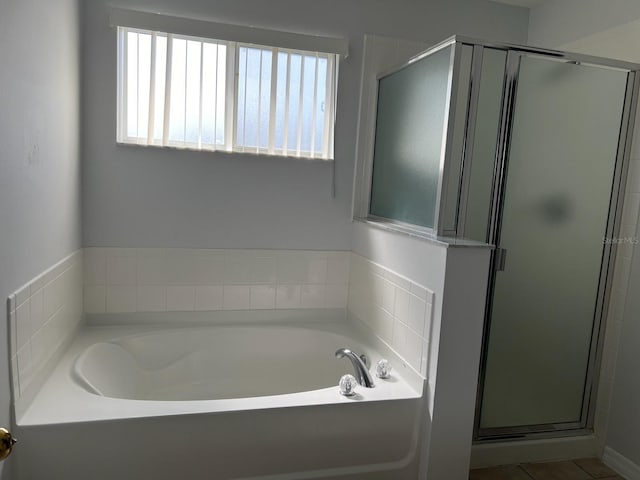 bathroom with separate shower and tub and plenty of natural light