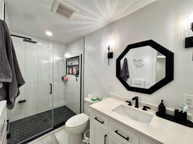 bathroom featuring tile patterned floors, vanity, toilet, and a shower with shower door