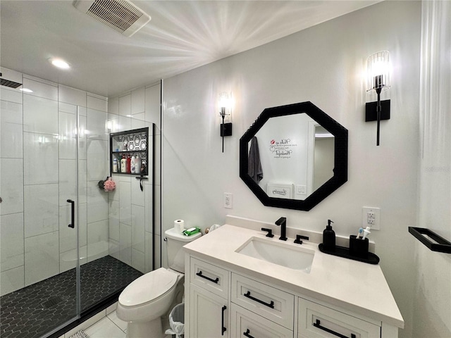 bathroom featuring tile patterned flooring, vanity, toilet, and a shower with door