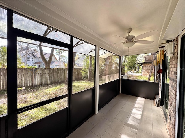 unfurnished sunroom with ceiling fan and a healthy amount of sunlight