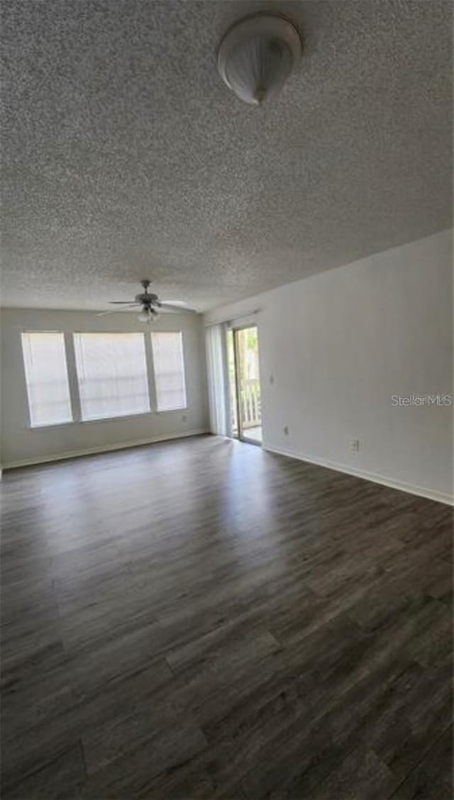 empty room with a textured ceiling, ceiling fan, and dark wood-type flooring