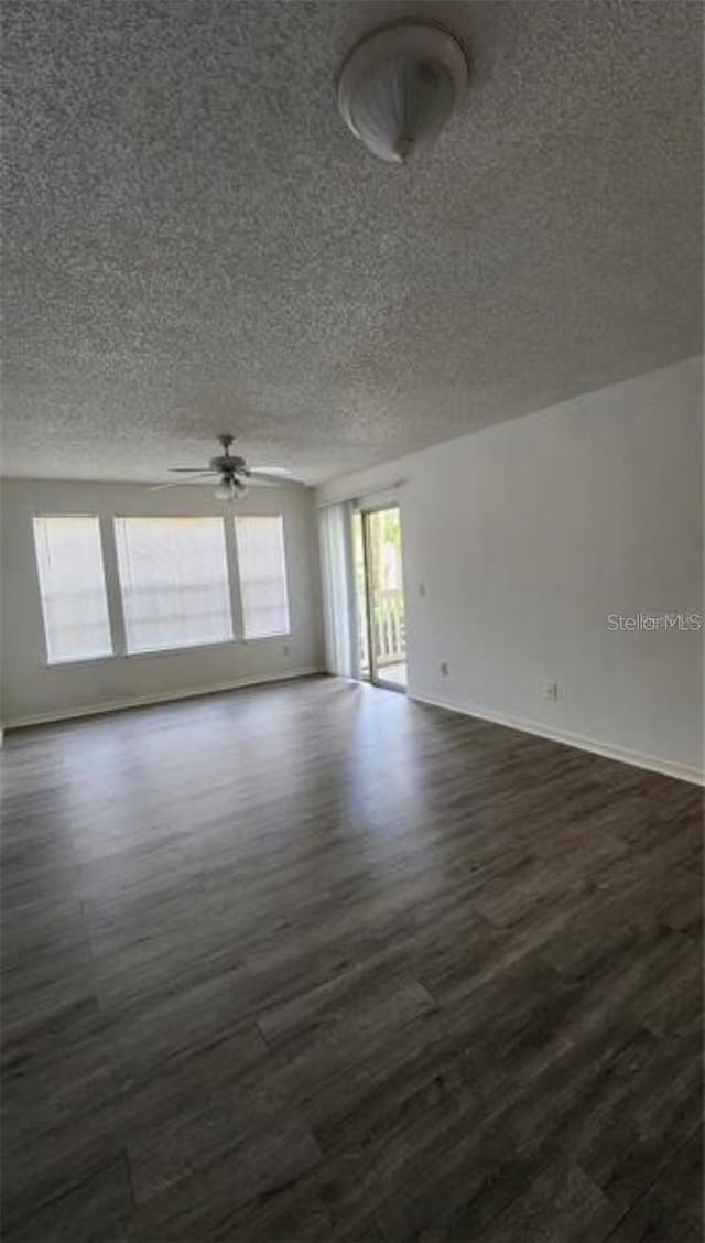 1025 S Hiawassee Rd Unit 2216, Orlando, FL 32835 - empty room featuring a textured ceiling, dark wood-type flooring, a ceiling fan, and baseboards