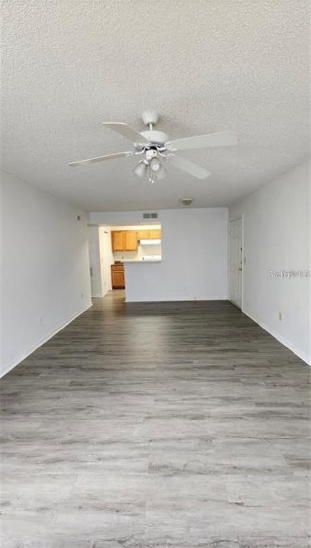 interior space featuring hardwood / wood-style flooring, ceiling fan, and a textured ceiling