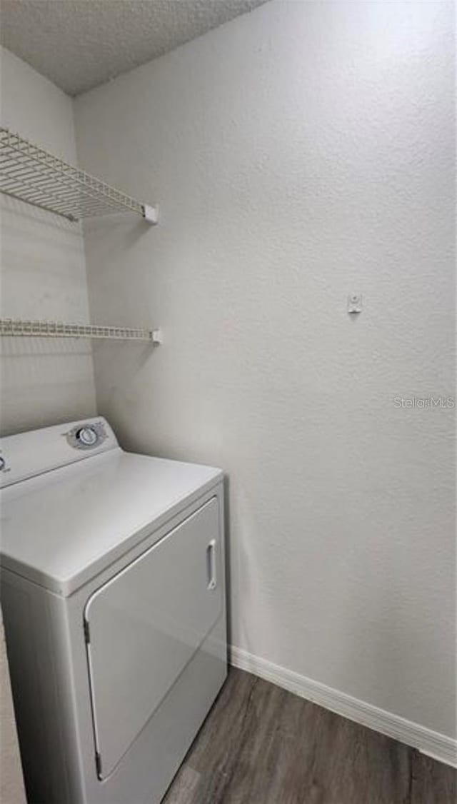 laundry room with washer / dryer, a textured ceiling, and dark wood-type flooring