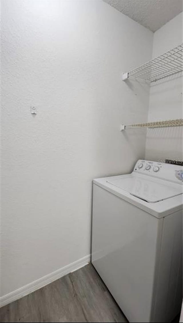 laundry area featuring hardwood / wood-style floors, washer / dryer, and a textured ceiling