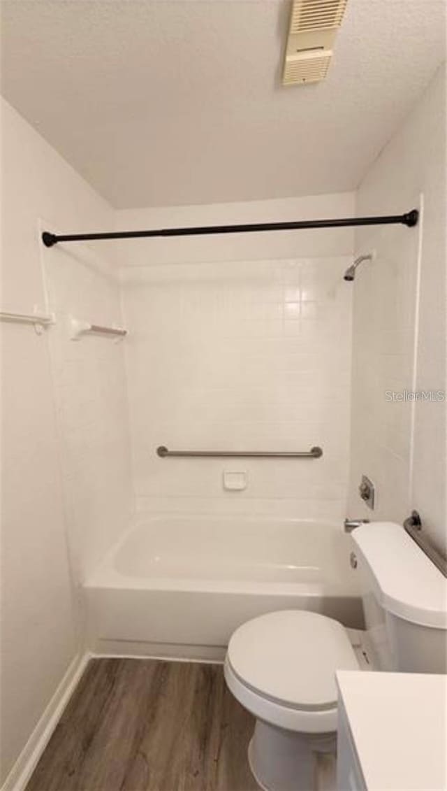 full bathroom featuring vanity, hardwood / wood-style flooring, toilet, and tiled shower / bath