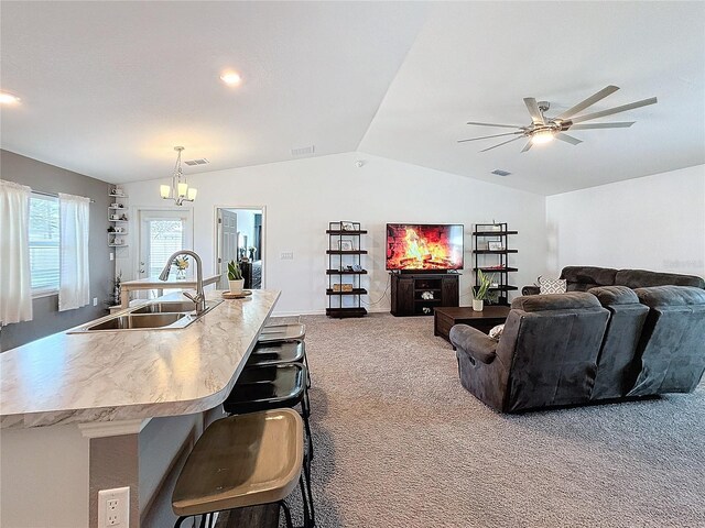 kitchen with carpet flooring, sink, a breakfast bar area, lofted ceiling, and an island with sink