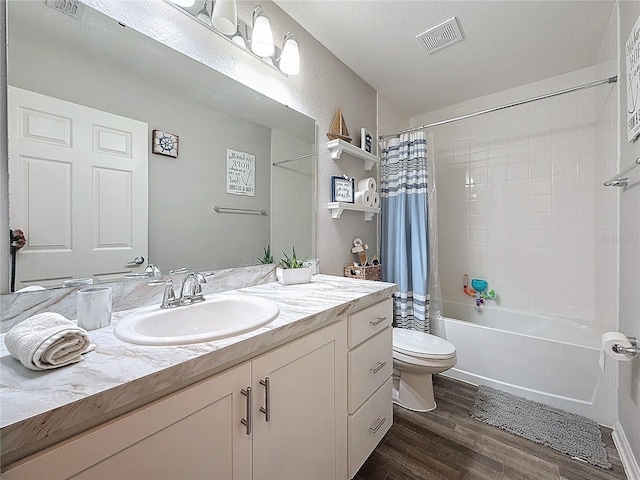 full bathroom featuring shower / bath combination with curtain, wood-type flooring, a textured ceiling, toilet, and vanity