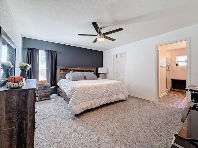 carpeted bedroom with ceiling fan, a textured ceiling, and ensuite bath