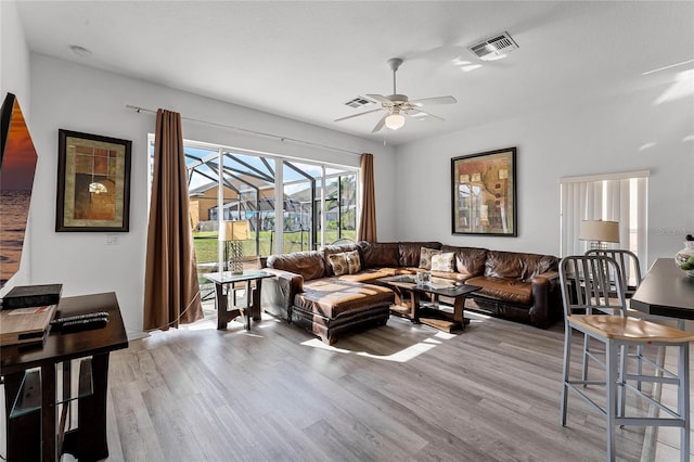 living room featuring ceiling fan and light wood-type flooring