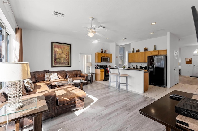 living room with ceiling fan and light hardwood / wood-style floors