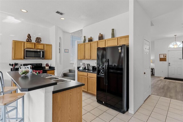 131 Cadiz Loop, Davenport, FL 33837 - kitchen with black appliances, dark countertops, light tile patterned floors, a kitchen bar, and recessed lighting