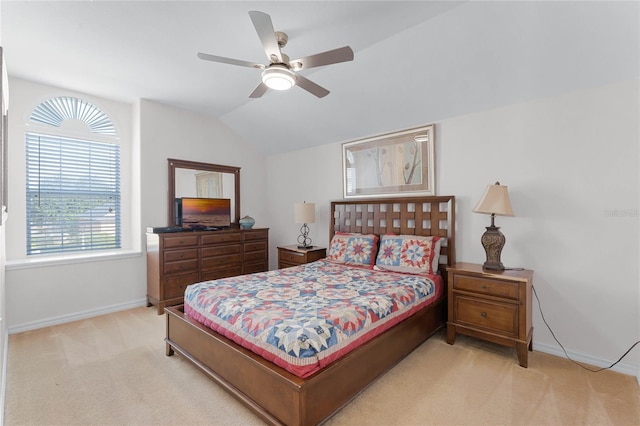 carpeted bedroom with ceiling fan and vaulted ceiling