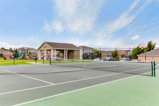 view of tennis court with a playground and basketball hoop