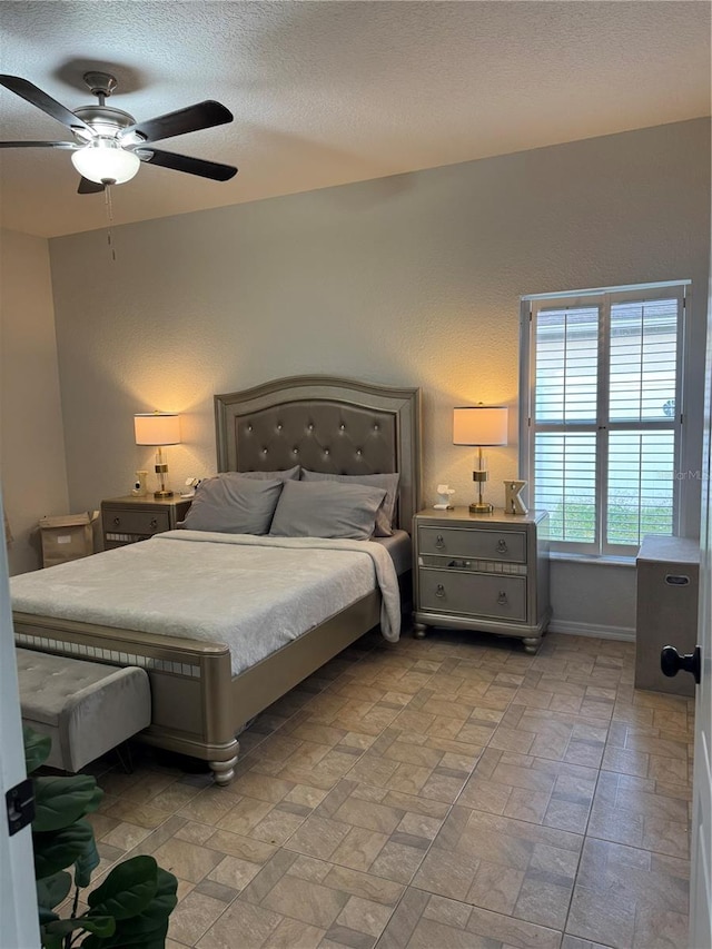 bedroom with ceiling fan and a textured ceiling