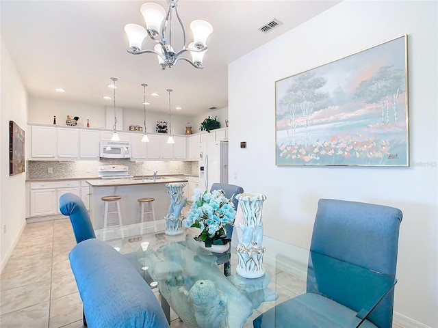 tiled dining area with a chandelier and sink