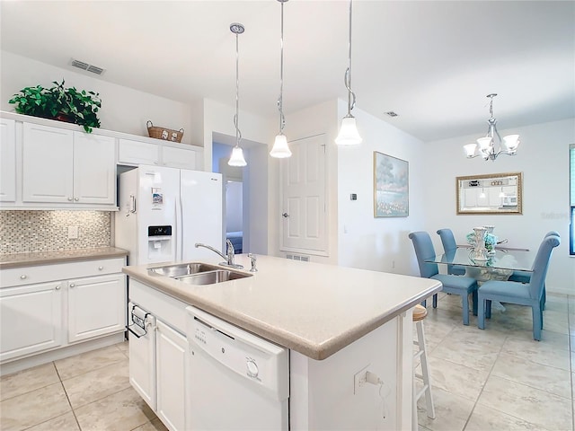 kitchen featuring white cabinets, white appliances, a center island with sink, and sink