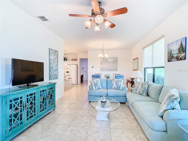 tiled living room with ceiling fan with notable chandelier